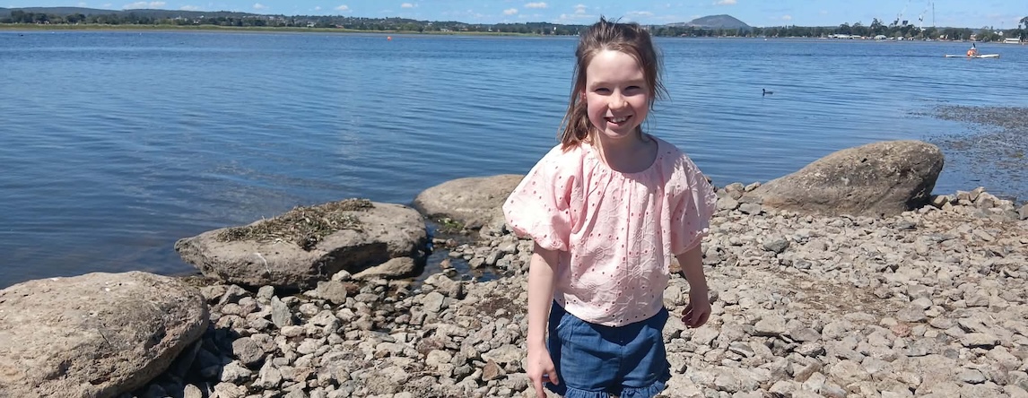 Apraxia patient Isla, 9, standing on a beach, has needed speech therapy